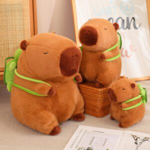 Three capybara plush toys of varying sizes with green backpacks, arranged in a cozy indoor setting.